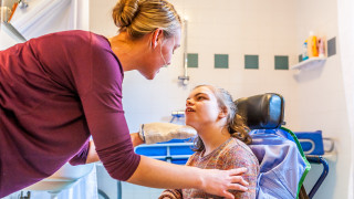 Hoitaja ja nuori nainen vammaispalveluissa.