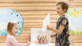 Tyttö ja poika leikkivät ja piirtävät.