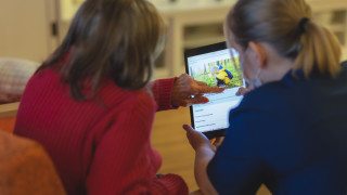 Sote-ammattilainen opastaa tablettilaitteen käytössä.