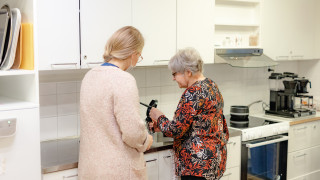 Kaksi henkilöä keittiössä keittämässä kahvia.