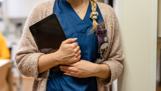 Sote-ammattilainen tablettilaite kädessään.