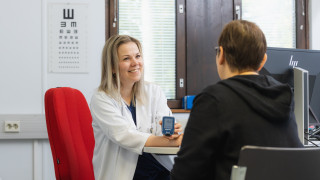 Lääkäri mittaa asiakkaan verensokerin.