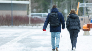 Kaksi henkilöä kävelevät pihalla.