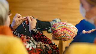 Henkilö kutoo villalangalla.