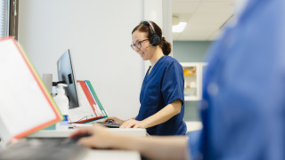 Sote-ammattilainen tietokoneen ääressä.