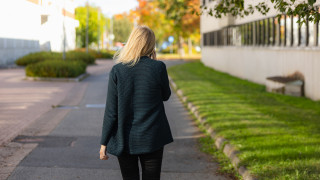 Henkilö kävelee kadulla ja puhuu matkapuhelimeen.