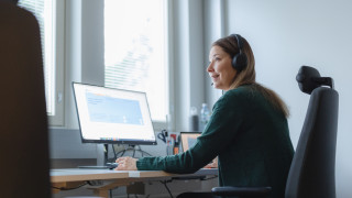 Sosiaaliohjaaja istuu tietokoneen ääressä