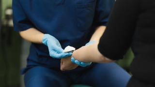 Hoitaja auttaa potilasta.