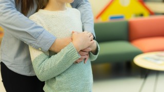 Aikuinen ja lapsi halaavat.