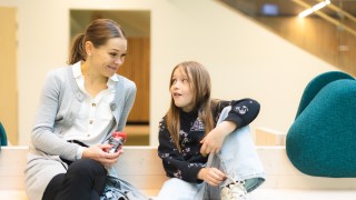 Aikuinen ja lapsi istuu penkillä.