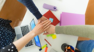 Yhteistyö, kolme kättä päällekkäin yhdessä.