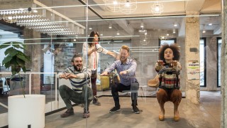 Ihmiset pitävät taukoa toimistotyöstä tekemällä kyykkyjä.