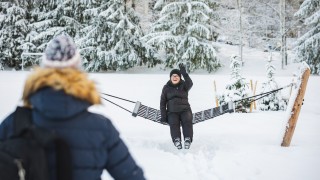 Ikääntynyt ulkoilija vilkuttaa riippukeinusta ystävälle