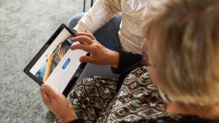 Kuvassa henkilö tutkii tabletilta digipalveluita.