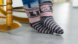 Villasukat keinutuolissa istuvan ihmisen jaloissa