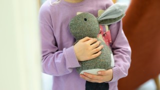 Lapsi pitää pehmolelua sylissään.