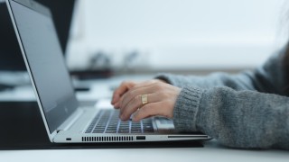 Henkilö kirjoittaa tietokoneella