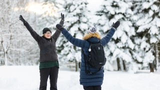 Kaksi henkilöä jumppaa talvimaisemissa