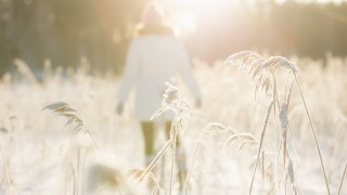 Henkilö kävelemässä rannalla talvella aurinkoisella säällä