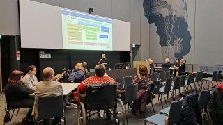 Vaikuttamistoimielimen edustajia kokoontuneena katsomaan yhteistä diaesitystä.