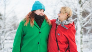 Nuori ja aikuinen katsovat toisiinsa talvisessa maisemassa.