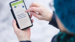 Asiakas käyttää puhelimella Keski-Suomen hyvinvointialueen palveluita.