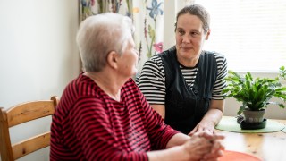 Kaksi henkilöä katsoo toisiinsa ja juttelee.