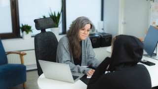 Sosiaalityöntekijä keskustelee nuoren aikuisen asiakkaan kanssa