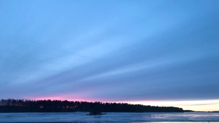 Talvinen auringonlasku järvellä.