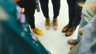 Ringissä seisovien ihmisten jalat ja kengät näkyvät