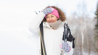 Aikuinen hiihtämässä talvisessa maisemassa.