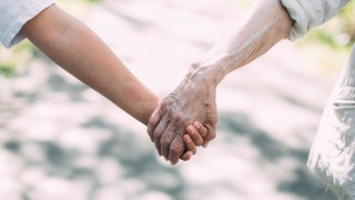 Kaksi ihmistä pitävät toisiaan kädestä kiinni.
