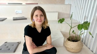 Annu Karkama istuu oleskeluun sopivalla portaikolla vieressään huonekasvi. 