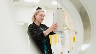 Keski-Suomen hyvinvointialueen ammattilainen tarkastelee kuvantamisen laitetta.