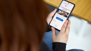 Henkilö pitää käsissään älypuhelinta