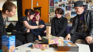 Nuoria aikuisia pelaamassa huojuvaa tornia.