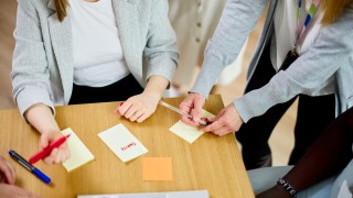 Ihmiset työskentelevät post-it-lapuilla.