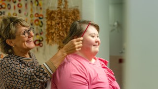 Keski-Suomen hyvinvointialueen ammattilainen kampaa asiakkaan hiuksia. 