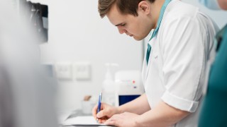 Päivystyksen ammattilainen kirjaa potilaan tietoja muistiin.