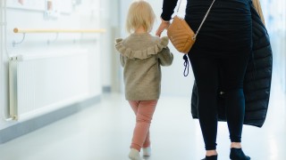 Lapsi ja vanhempi kävelevät neuvolan käytävällä.