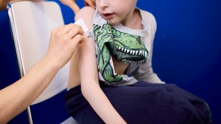 Lapsi saa rokotuksen olkavarteen hoitajan toimesta.