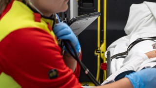 Ensihoitaja ambulanssissa stetoskooppi korvilla