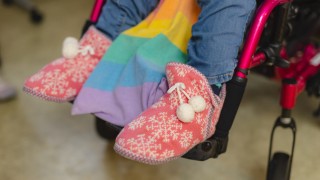 Henkilö istuu pyörätuolissa.