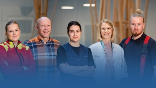 Hyvinvointialueen ammattilaisia seisoo rivissä ja katsoo hymyillen kameraan.