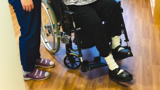 Henkilö istuu pyörätuolissa.