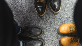 Ihmiset seisovat piirissä, kenkien kärjet osoittavat keskelle.