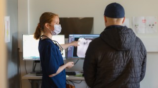 Suuhygienisti kertoo asiakkaalle suun terveydestä.