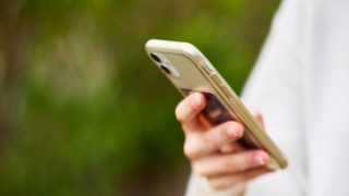 Henkilö pitää älypuhelinta kädessään