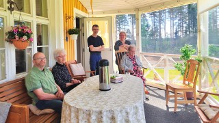 Kuvassa ihmisiä istumassa pöydän ääressä.