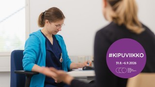 Terveydenhuollon ammattilainen ja asiakas istuvat vastakkain pöydän ääressä. Ammattilainen tekee merkintöjä paperille. Violetissä ympyrässä valkoinen teksti: 'Kipuviikko'.
